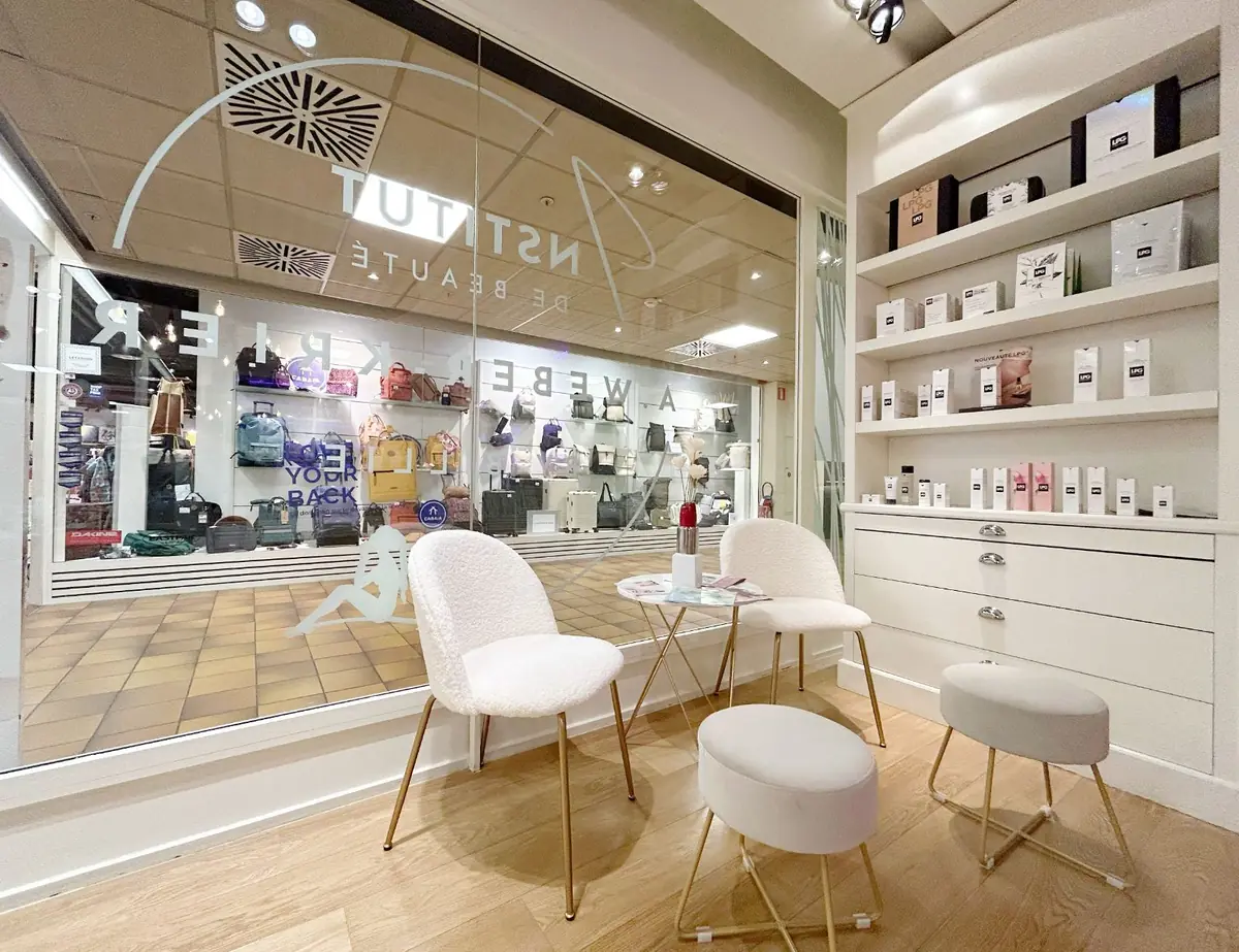 Coin d’attente avec deux fauteuils clairs près de la vitrine